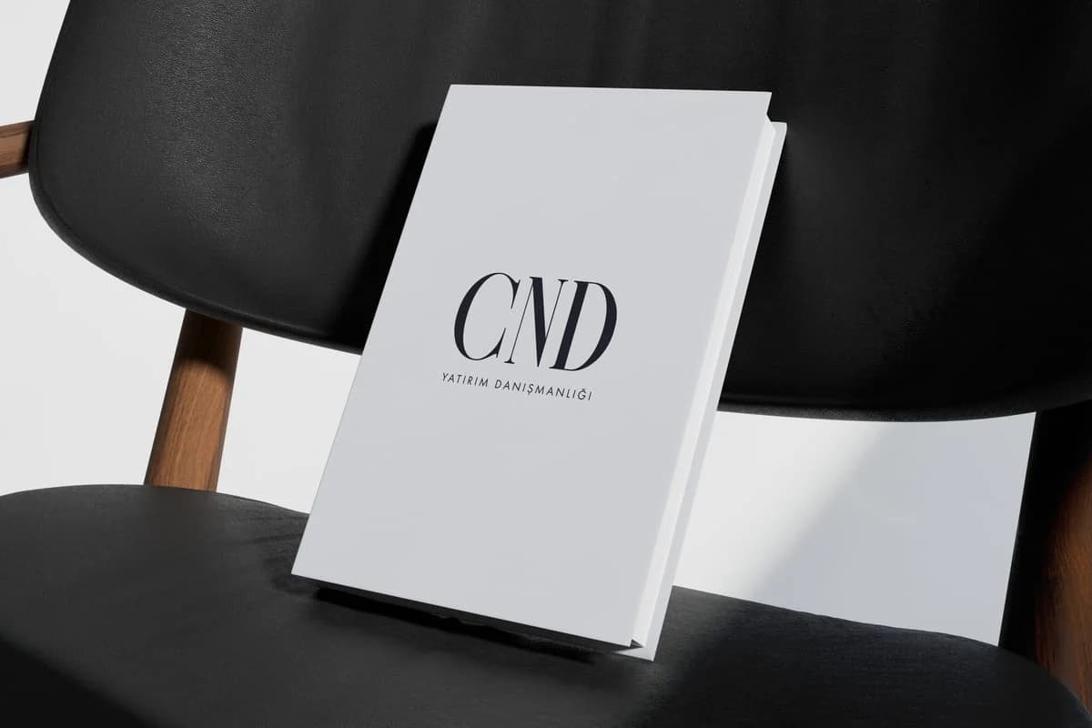 White book with the CND Yatırım Danışmanlığı logo on a black chair