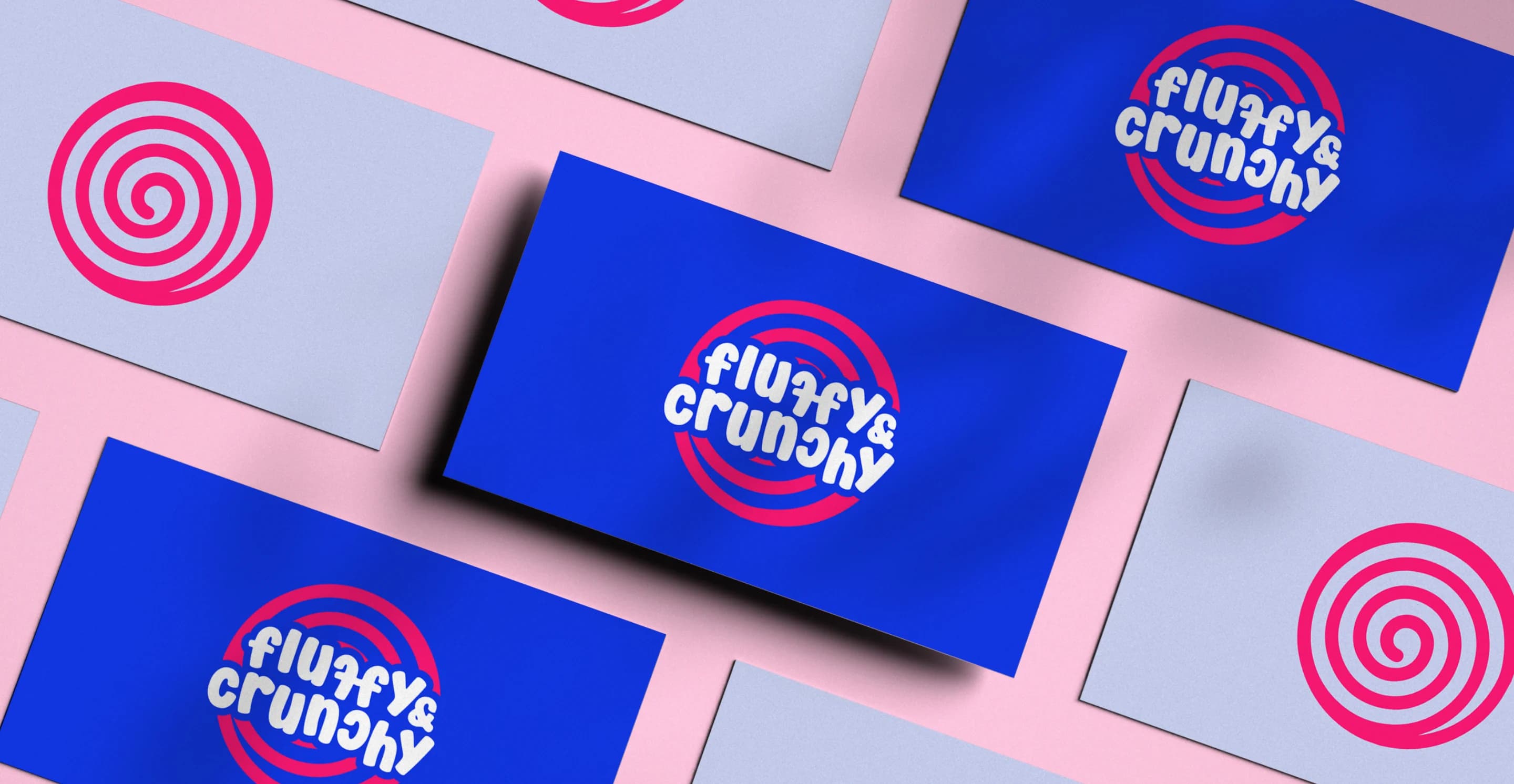 Business cards with the badge on royal blue and the swirl mark on pale blue