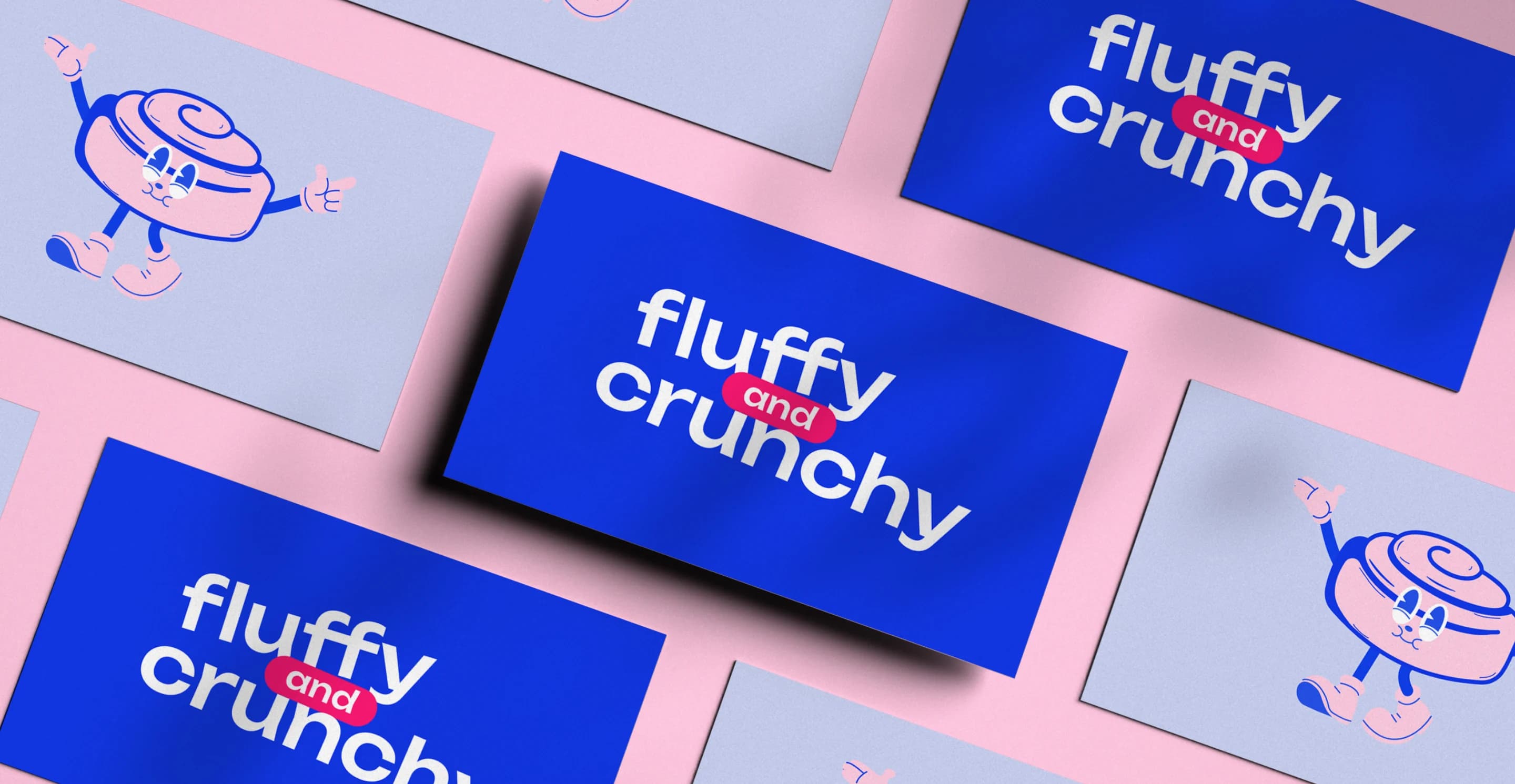 Fluffy and Crunchy business cards in royal blue and pale blue, with the wordmark and the cinnamon roll mascot