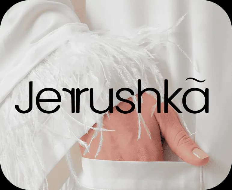 Jerrushkâ logo over a white satin set with feather cuffs