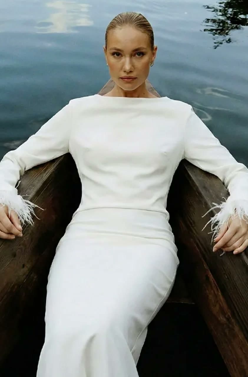 AI model in a white feather-cuff dress, sitting in a wooden boat