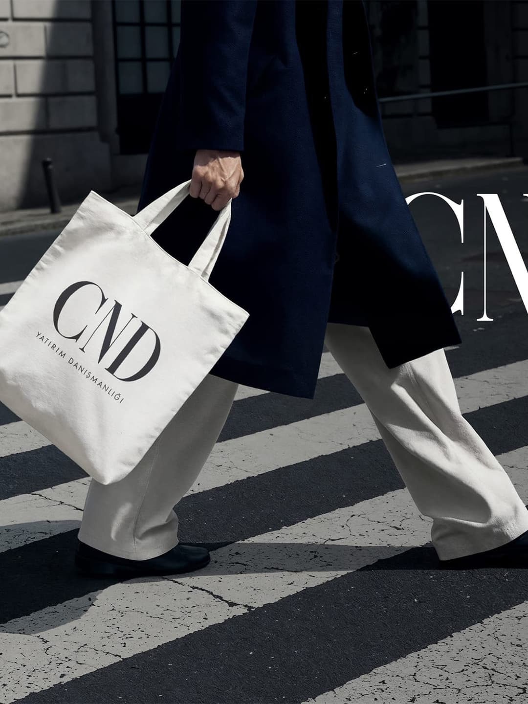 CND Yatırım Danışmanlığı tote bag carried across a pedestrian crossing